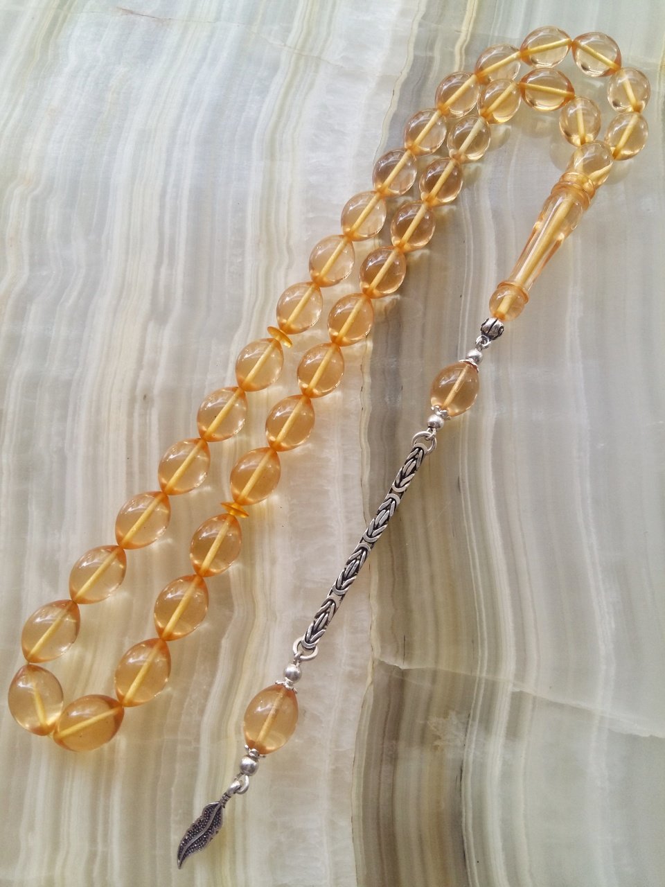 Özel İşçilikli Atölye Yapımı 925 Ayar Gümüş Püsküllü Ateş Kehribar Tesbih.Ürün Piyasanın en iyi Hammaddesinden Yapılmış Olup Canlı Rengiyle, Yumuşak Dokusu ve Kusursuz İşçiligiyle Tesbih Severlerin Beğenisine Sunulmuştur.