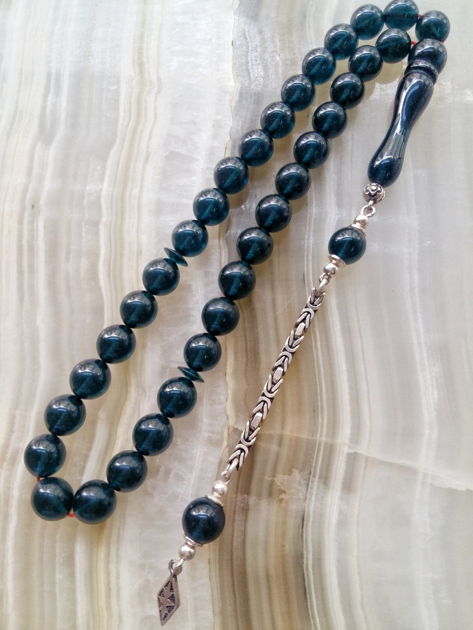 Özel İşçilikli Atölye Yapımı 925 Ayar Gümüş Püsküllü Ateş Kehribar Tesbih.Ürün Piyasanın en iyi Hammaddesinden Yapılmış Olup Canlı Rengiyle, Yumuşak Dokusu ve Kusursuz İşçiligiyle Tesbih Severlerin Beğenisine Sunulmuştur.