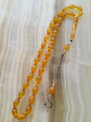 Özel İşçilikli Atölye Yapımı 925 Ayar Gümüş Püsküllü Sıkma Kehribar Tesbih.Ürün Piyasanın en iyi Hammaddesinden Yapılmış Olup Canlı Rengiyle, Yumuşak Dokusu ve Kusursuz İşçiligiyle Tesbih Severlerin Beğenisine Sunulmuştur.