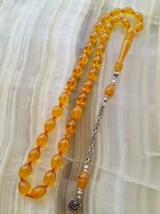 Özel İşçilikli Atölye Yapımı 925 Ayar Gümüş Püsküllü Sıkma Kehribar Tesbih.Ürün Piyasanın en iyi Hammaddesinden Yapılmış Olup Canlı Rengiyle, Yumuşak Dokusu ve Kusursuz İşçiligiyle Tesbih Severlerin Beğenisine Sunulmuştur.