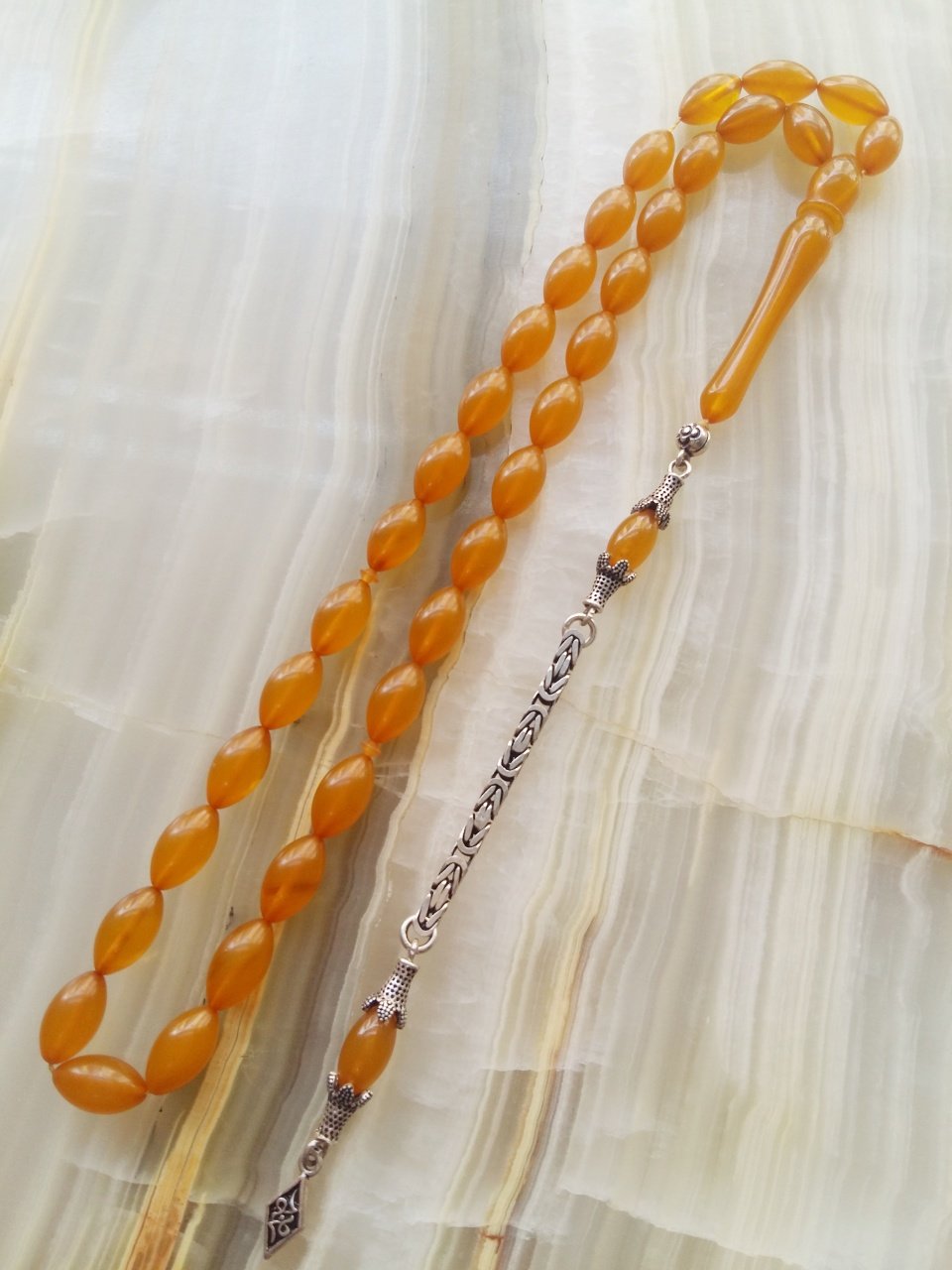 Özel İşçilikli Atölye Yapımı 925 Ayar Gümüş Püsküllü Sıkma Kehribar Tesbih.Ürün Piyasanın en iyi Hammaddesinden Yapılmış Olup Canlı Rengiyle, Yumuşak Dokusu ve Kusursuz İşçiligiyle Tesbih Severlerin Beğenisine Sunulmuştur.p