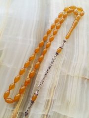 Özel İşçilikli Atölye Yapımı 925 Ayar Gümüş Püsküllü Sıkma Kehribar Tesbih.Ürün Piyasanın en iyi Hammaddesinden Yapılmış Olup Canlı Rengiyle, Yumuşak Dokusu ve Kusursuz İşçiligiyle Tesbih Severlerin Beğenisine Sunulmuştur.p