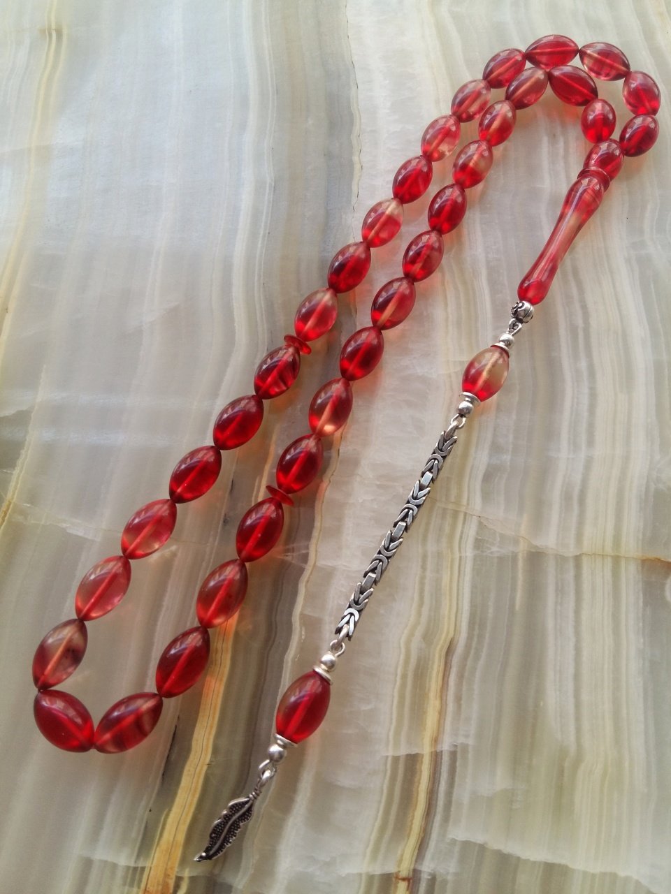 Özel İşçilikli Atölye Yapımı 925 Ayar Gümüş Püsküllü Sıkma Kehribar Tesbih.Ürün Piyasanın en iyi Hammaddesinden Yapılmış Olup Canlı Rengiyle, Yumuşak Dokusu ve Kusursuz İşçiligiyle Tesbih Severlerin Beğenisine Sunulmuştur.