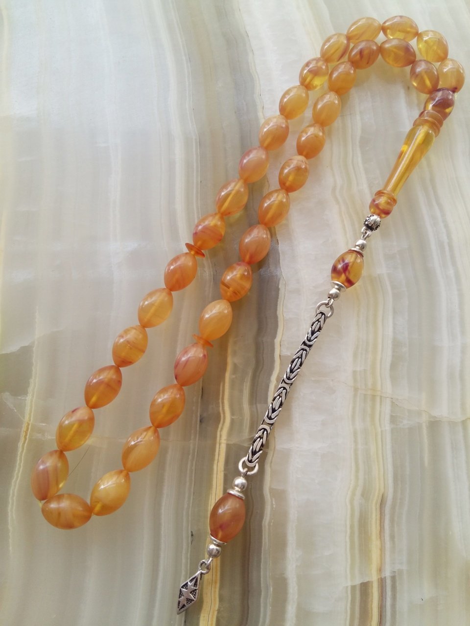 Çektikçe Parlayacak Hareli 925 Ayar Gümüş Püsküllü Sıkma Kehribar Tesbih. Tesbih Malzemesi Piyasanın en iyi Hammadesinden Yapılmış Olup Canlılık Renk Yumuşak Dokusu ve Kusursuz Isciligiyle Tesbih Severlerin Beğenisine Sunulmuştur.