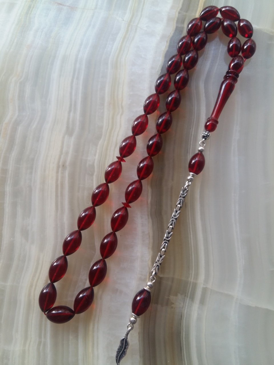 Özel İşçilikli Atölye Yapımı 925 Ayar Gümüş Püsküllü Ateş Kehribar Tesbih.Ürün Piyasanın en iyi Hammaddesinden Yapılmış Olup Canlı Rengiyle, Yumuşak Dokusu ve Kusursuz İşçiligiyle Tesbih Severlerin Beğenisine Sunulmuştur.