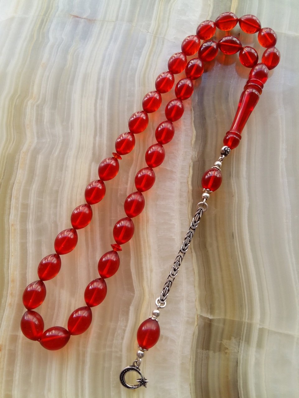 Özel İşçilikli Atölye Yapımı 925 Ayar Gümüş Püsküllü Ateş Kehribar Tesbih.Ürün Piyasanın en iyi Hammaddesinden Yapılmış Olup Canlı Rengiyle, Yumuşak Dokusu ve Kusursuz İşçiligiyle Tesbih Severlerin Beğenisine Sunulmuştur.