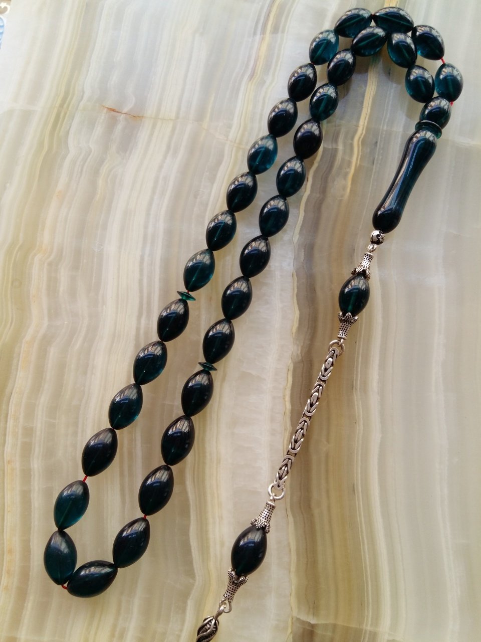 Özel İşçilikli Atölye Yapımı 925 Ayar Gümüş Püsküllü Ateş Kehribar Tesbih.Ürün Piyasanın en iyi Hammaddesinden Yapılmış Olup Canlı Rengiyle, Yumuşak Dokusu ve Kusursuz İşçiligiyle Tesbih Severlerin Beğenisine Sunulmuştur.